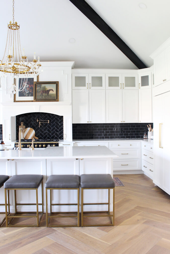 Neutral Kitchen With White Cabinets And Wood Herringbone Floors