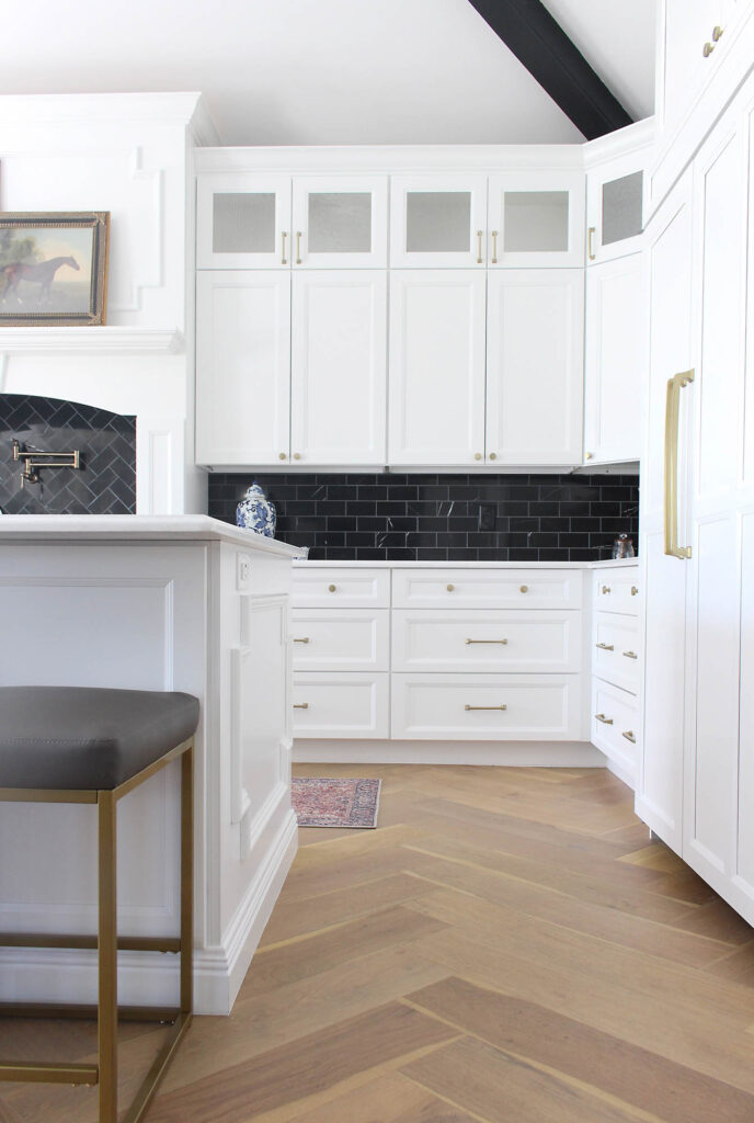 Wood Herringbone Floors In Kitchen With White Cabinets